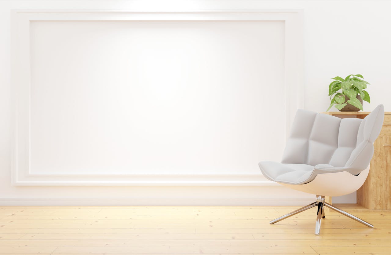 Minimalist room featuring a modern chair and lush green plant against a bright backdrop.